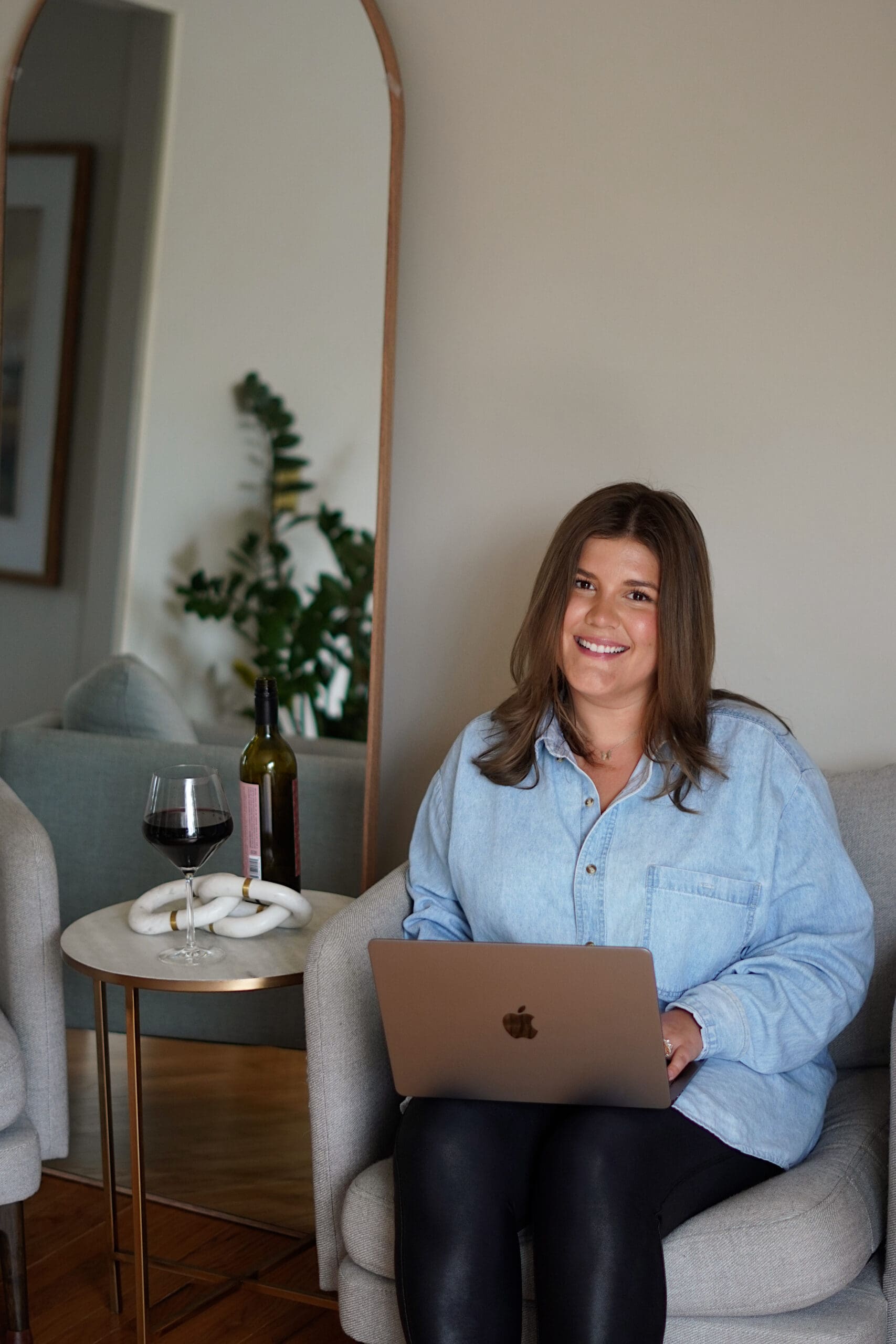 A digital marketing strategist holding a laptop in an office chair