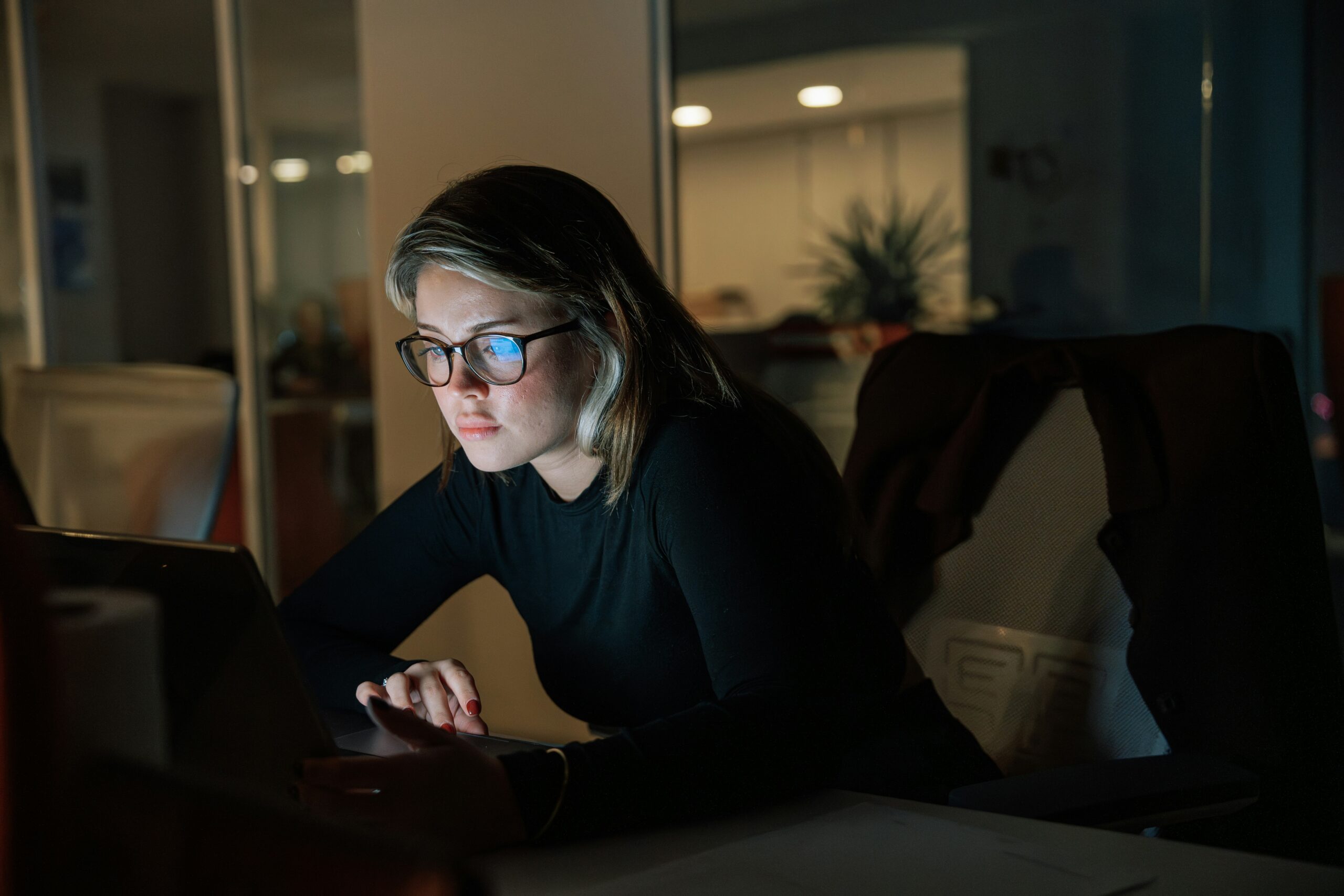 A woman writing blog ideas on a laptop